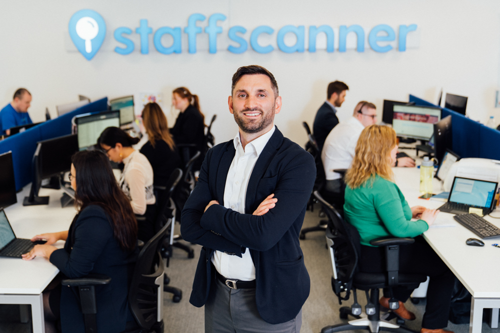 professional photo of man standing in the office with arms crossed